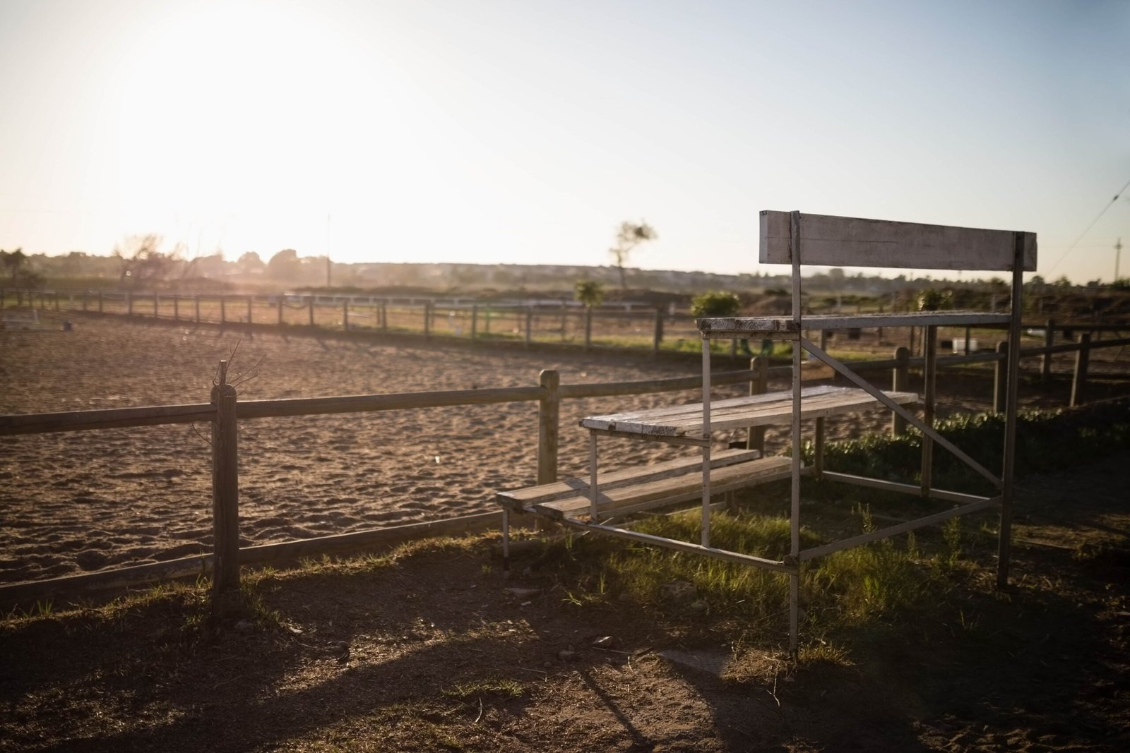 A black and white, low-angle perspective shot of a long concrete irrigation channel filled with water, stretching through the center of a rural paddy field in Sekinchan.